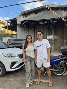 a man wearing a nike shirt is standing next to a woman