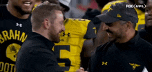 a man shaking hands with a man wearing a jersey with the number 5 on it
