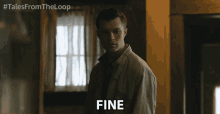 a man is standing in a room and the word fine is on his face