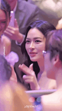 a woman in a white dress is applauding a man in a crowd
