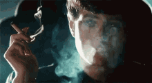 a man is smoking a cigarette and the smoke is coming out of his mouth .