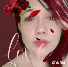 a woman 's face is surrounded by red roses and the word love is above her