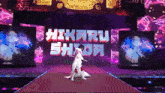 a woman is walking down a red carpet in front of a large screen that says hikaru shida