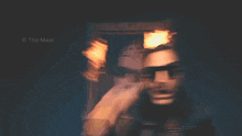 a man wearing sunglasses is standing in front of a framed picture with the caption the maw