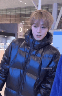 a man wearing a blue nike jacket stands in front of a sign that says d.