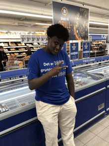 a person wearing a blue shirt that says det er 100 grunn