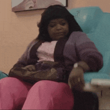 a woman sits in a chair with the number 3 on the back