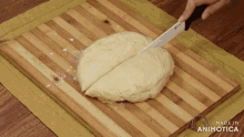 a person is cutting a piece of dough on a wooden cutting board made in animatica