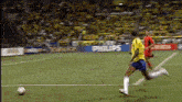 a soccer player in a yellow jersey is kicking a soccer ball