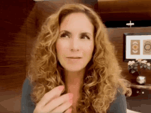a woman with curly hair is looking up at something