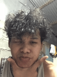 a man with curly hair is wearing a tank top that says take the easy way on it