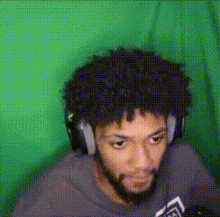 a man with a beard is wearing headphones and looking at the camera .
