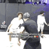 a group of young men are playing basketball on a court and one of them is holding a basketball in his hand .