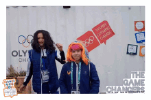 two girls pose in front of a wall that says youth olympic games