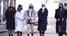 a group of women wearing face masks are standing next to each other