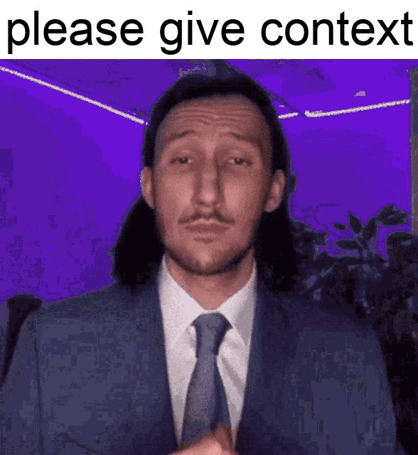 a man in a suit and tie is giving a speech and asking for context