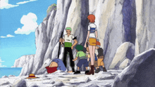 a group of anime characters are standing on a rocky beach near the ocean