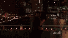 a couple kissing on a balcony with the word global on the bottom right