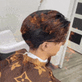 a man wearing a brown louis vuitton cape