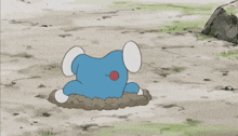 a blue cartoon character with a red nose is laying on its back in the dirt