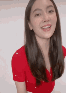 a woman wearing a red shirt with white hearts on it