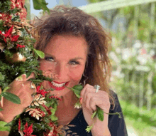 a woman with a ring on her finger is eating flowers from a christmas tree