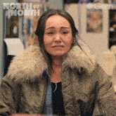 a woman is wearing a jacket with a fur collar and the words north of north on the top