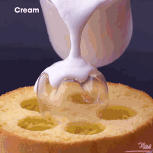 a cake with holes in it is being decorated with white cream