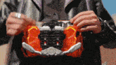 a man in a black jacket is holding a toy that says ' samurai ' on the front