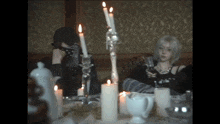 a man and a woman are sitting at a table with candles and wine glasses .