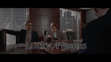 two men sitting at a table with the words " lucky i guess " on the screen