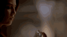 a close up of a woman holding a glass object in her hand .