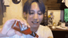 a young man with blue hair is holding a can of coca cola in his hands .