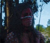 a man with red paint on his face and white polka dots on his arms