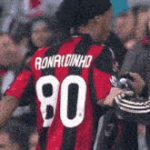 a soccer player named ronaldinho wears a red and black jersey
