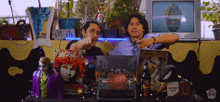 two men are sitting at a table with a mosca album