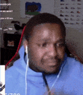 a man wearing headphones is making a funny face while sitting in front of a microphone .