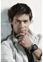 a man with his hand on his chin wears a watch