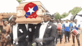 a group of men are carrying a coffin with a star on it that says ' as wisma ' on it