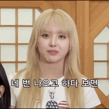 a girl with blonde hair is wearing a white t-shirt with an american flag on it