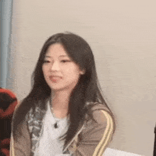 a young woman is sitting in a chair with her tongue out and making a funny face .