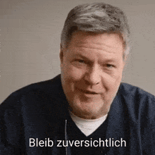 a close up of a man 's face with the words „ bleib zuversichtlich ” written on the bottom .