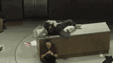 a man and a woman are sitting on a counter in a kitchen . the woman is wearing a mask .