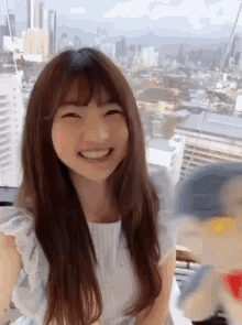 a girl is smiling in front of a view of a city
