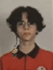a blurry picture of a person with glasses and a red jacket