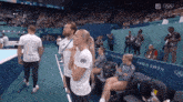 a group of people standing in a stadium with a sign that says paris 2024
