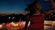 a woman in a red dress with her arms up in the air