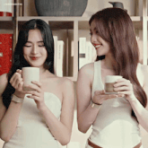two women standing next to each other holding cups of coffee and smiling with the words lingdomoise above them