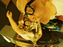 a man wearing glasses is drinking out of a wine glass