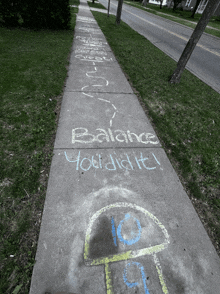 a sidewalk has chalk drawn on it that says balance you did it
